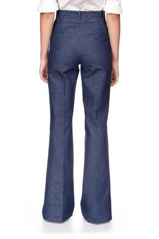 back profile model wearing Danae High Waisted Flared denim Pants with front pockets and gold exposed zipper closure