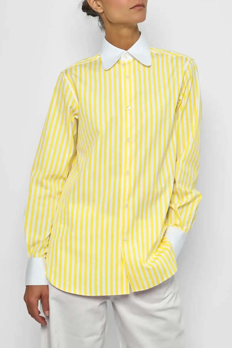 front profile model wearing Dandy Shirt yellow white vertical stripe Exaggerated white curved collar set against bright yellow striped cotton poplin
Straight cut - classic fit
Back yoke with pleat
Round collar
Rounded cuff
Mother-of-pearl buttons
Medium weight cotton
100% two-ply cotton poplin woven in Italy