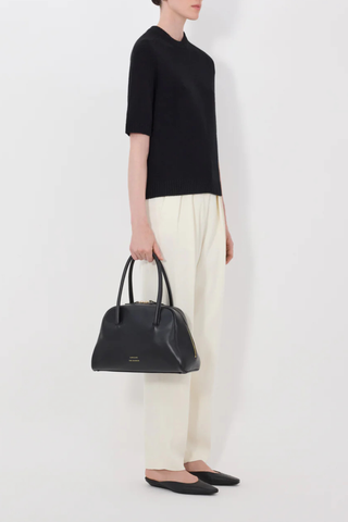 side profile model wearing Dara Cashmere Black 100% Cashmere
Straight fit
Elbow-length raglan sleeves
Crew neck with rib details