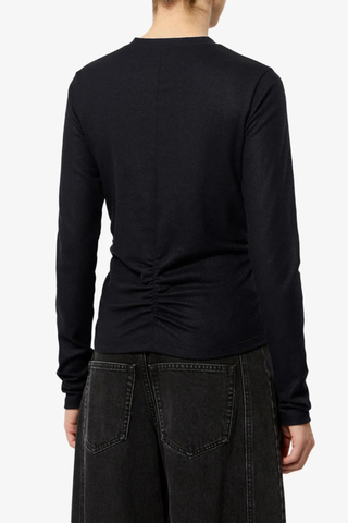 back profile model wearing Delesa Ruched Flannel Jersey Top black Ruched top in solid flannel jersey
Fitted silhouette
Ruching at the front and back
Round neckline
Long sleeves
Polyester 66% Wool 29% Elastane 5%