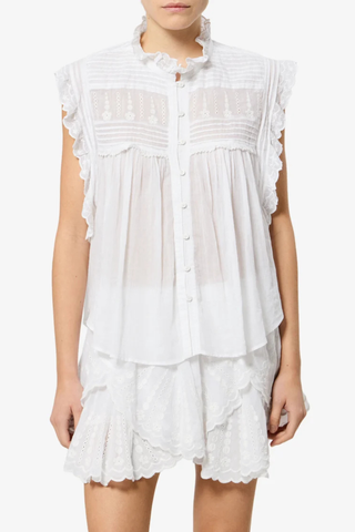 front profile model wearing Dersia Sleeveless Embroidered Top White cotton voile Straight fit
Front button closure
Pleated and embroidered bib
High round neckline with embroidered ruffle
Pleated shoulders
Ruffled armholes
Curved hem
100% Cotton