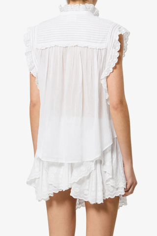 back profile model wearing Dersia Sleeveless Embroidered Top White cotton voile Straight fit
Front button closure
Pleated and embroidered bib
High round neckline with embroidered ruffle
Pleated shoulders
Ruffled armholes
Curved hem
100% Cotton