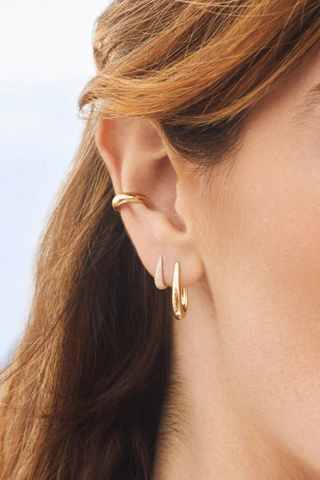 model wearing Diamond MIni Maeve Huggie Earring (Pair) yellow gold Diamond weight: 0.17 carats for the pair
Outer diameter: 12 mm
Finished with a latch closure