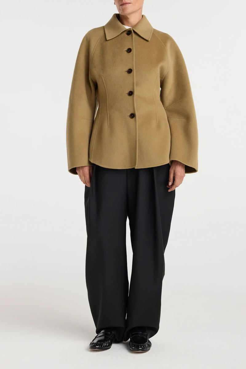 front profile model wearing  Double Faced Sculptural Jacket Camel
Cinched waist
Oversized sculptural sleeves
Four button closures
Side-seam welt pockets
Subtle front and back darts
95% wool 5% cashmere