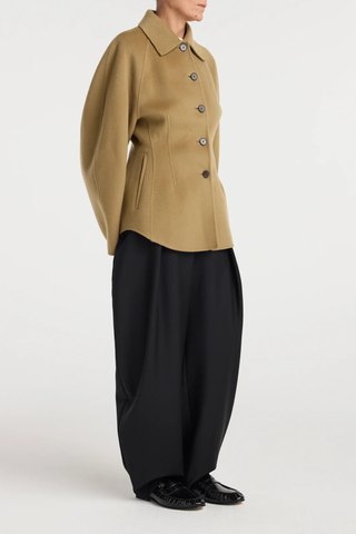 side profile model wearing  Double Faced Sculptural Jacket Camel
Cinched waist
Oversized sculptural sleeves
Four button closures
Side-seam welt pockets
Subtle front and back darts
95% wool 5% cashmere