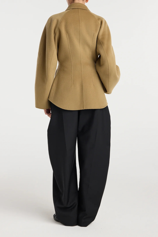 back profile model wearing  Double Faced Sculptural Jacket Camel
Cinched waist
Oversized sculptural sleeves
Four button closures
Side-seam welt pockets
Subtle front and back darts
95% wool 5% cashmere