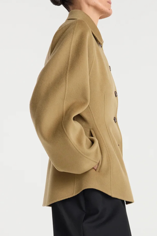 side profile model wearing  Double Faced Sculptural Jacket Camel
Cinched waist
Oversized sculptural sleeves
Four button closures
Side-seam welt pockets
Subtle front and back darts
95% wool 5% cashmere