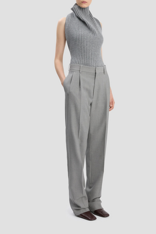 side profile model wearing Drop-Waist Straight Leg Trouser In Light Grey Melange virgin wool high waist front and low waist back design flat front 