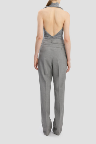 back profile model wearing Drop-Waist Straight Leg Trouser In Light Grey Melange virgin wool high waist front and low waist back design flat front 