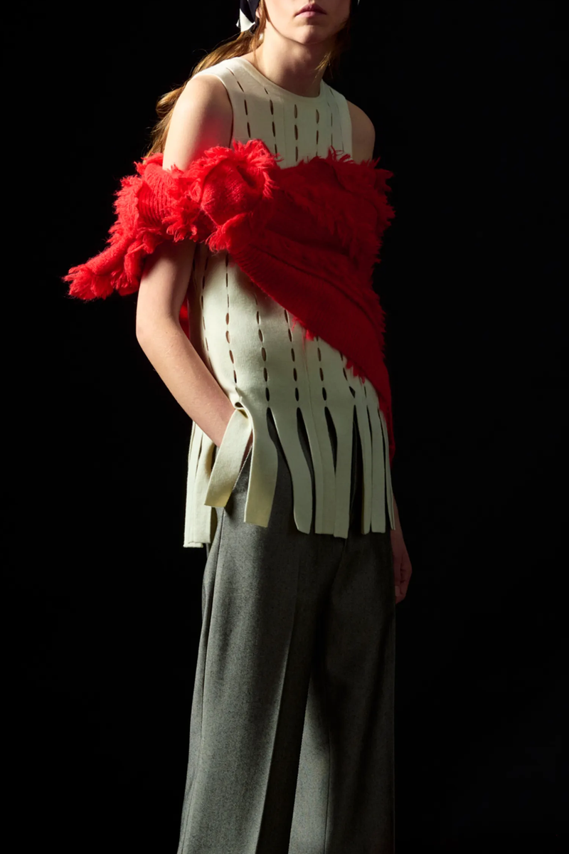 model wearing Eddie Perforated Intarsia Sleeveless ivory wool with fringe hem