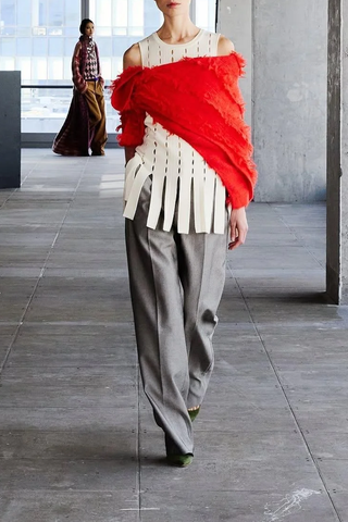 model wearing Eddie Perforated Intarsia Sleeveless ivory wool with fringe hem