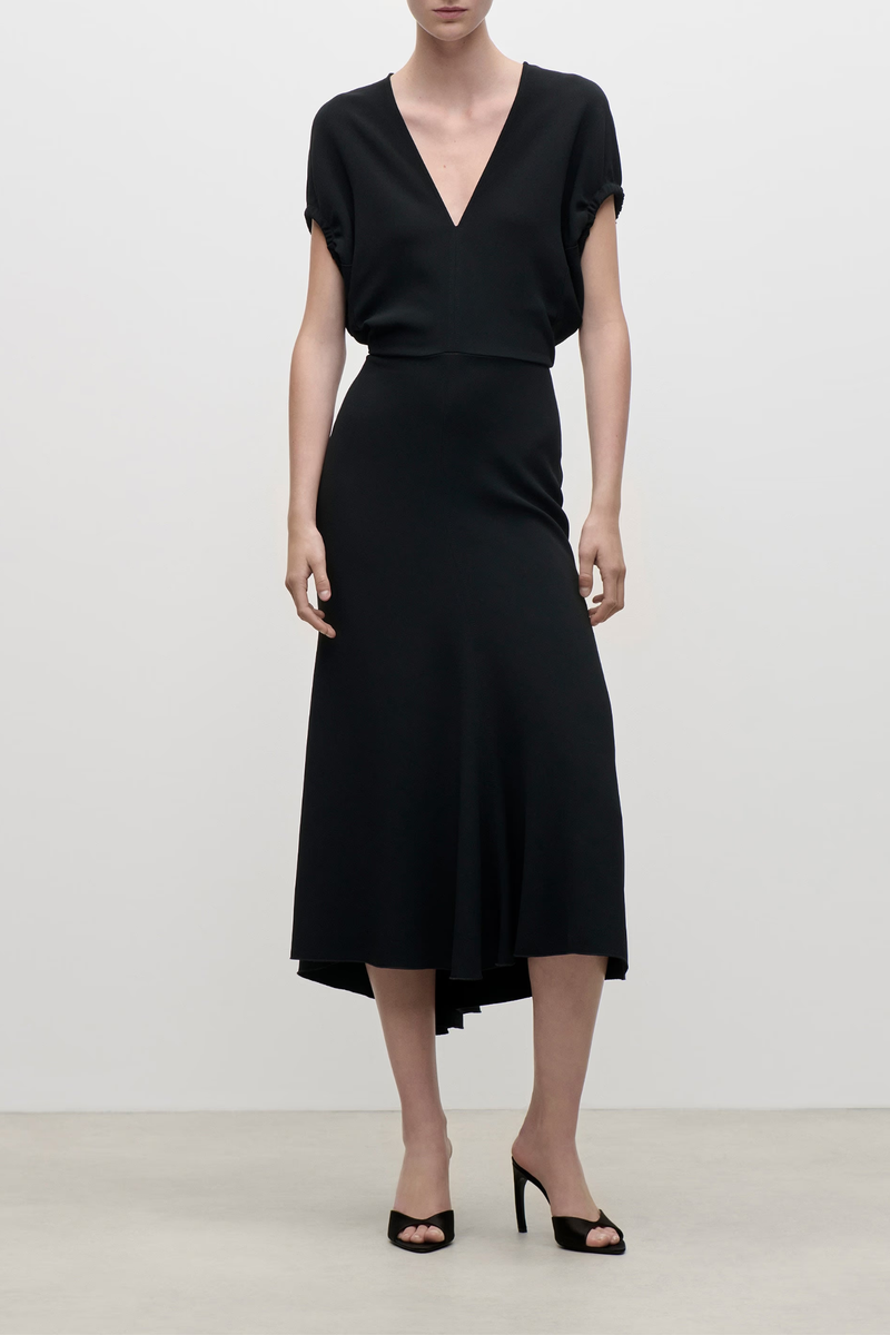 front profile model wearing  Edith Midi Fluid Cady Dress black Gathered sleeve
Directional rope edging
Front v-neckline with tonal topstitching
Flattering fitted waist
Longer-length hemline at the back
Blouson sleeve
Subtle asymmetrical hem
50% Viscose 47% Acetate 3% Elastane