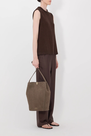 side profile model wearing Effy Boxy Sweater Vest Dark Brown Sleeveless sweater
Boxy fit
Rolled stand collar
Ribbed details on the neckline, armholes and hem