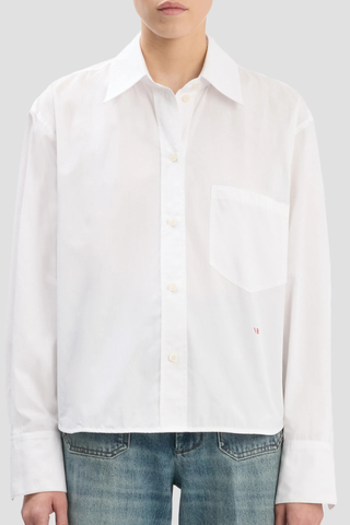 front profile model wearing  Ellys Shirt white Cropped length
Contrast red VB embroidery
Collared neckline
Chest pocket
100% Cotton