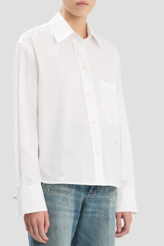 side profile model wearing  Ellys Shirt white Cropped length
Contrast red VB embroidery
Collared neckline
Chest pocket
100% Cotton