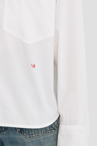 close up logo embroidery detail for Ellys Shirt white Cropped length
Contrast red VB embroidery
Collared neckline
Chest pocket
100% Cotton