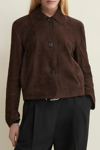 front profile model wearing Emy Suede Jacket Mud Brown  button down jacket
Cropped length and detailed with horn button closure and front pockets
Fits true to size, take your normal size
Dropped shoulder seam
100% goat suede