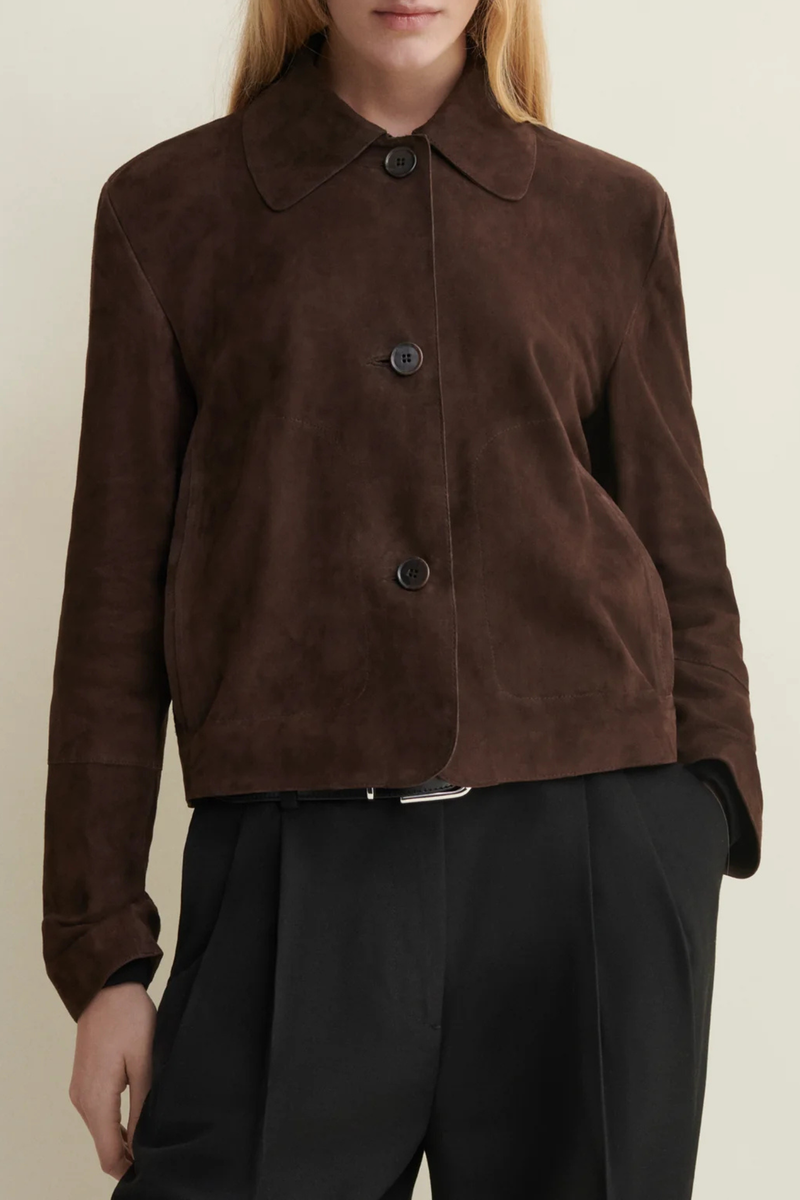 front profile model wearing Emy Suede Jacket Mud Brown  button down jacket
Cropped length and detailed with horn button closure and front pockets
Fits true to size, take your normal size
Dropped shoulder seam
100% goat suede