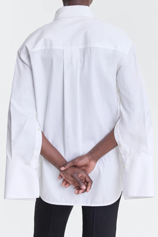 back profile model wearing Erin Slashed Boyfriend Shirt white Loose-fit shirt
Oxford cotton
Transformative button detailing
Sleeves can be unbuttoned or undone
Button front closure