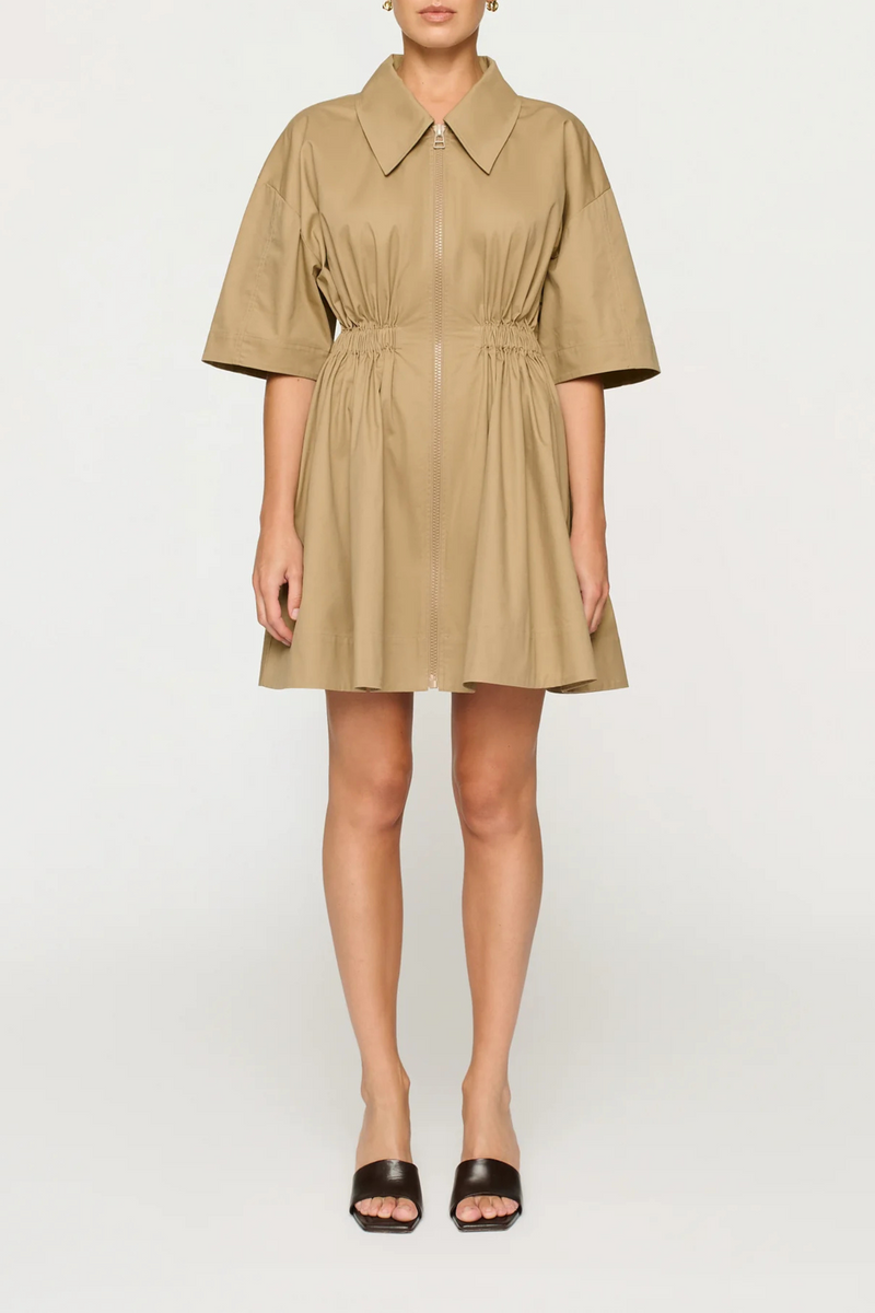 front profile model wearing Evander mini Dress cotton toffee low neckline, exaggerated collar, and a chunky front zipper 