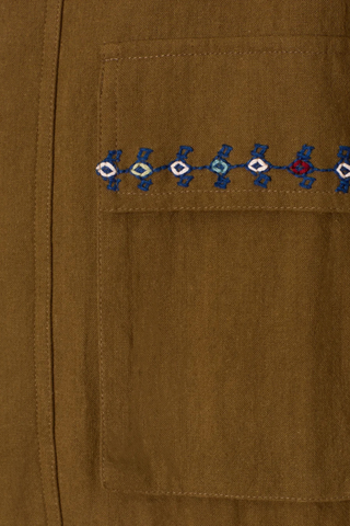 close up embroidery detail  Evelyn Olive Branch Army Jacket dark green Cotton twill
Utility style jacket
Flap pockets
Drawstring waist
Trimmed with hand embroidery and lined in leopard print
Blue embroidery details on the shoulder and flap pockets
100% Khadi Cotton
Snap Front with hidden front zip