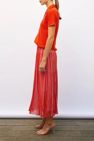 side profile model wearing Extra Textured Polo blood orange Fine, textured knit
Luxurious cotton yarn
Honeycomb-knit collar
Waffled knit
Smocked ruffled trim
Small buttons on the front