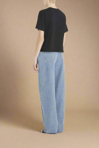 back profile of model wearing black boxy supima cotton v-neck t-shirt