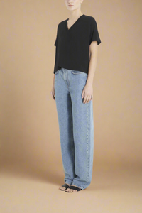 side profile of model wearing black boxy supima cotton v-neck t-shirt