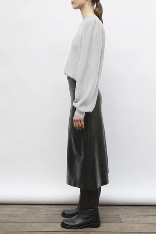 side profile model wearing Fab Midi Skirt Shiny New Wool deep black Long skirt
Milano knit reworked in a “leather” effect
Girdling waistband is hidden inside
Slightly flared silhouette
Back zipper
100% pure extra-fine virgin wool