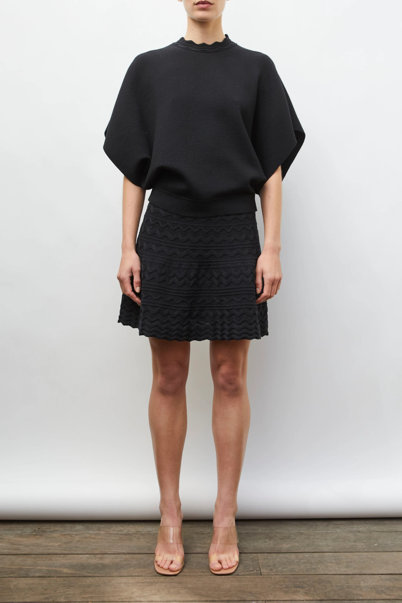 front profile model wearing  Fanta Top noir black Soft, modern fine-knit top
Generous cut
Neckline trimmed with a wide rick-rack edging
Enveloping armholes
Milano ribbed hem
90% pure laine vierge extra-fine, 7% polyamide, 3% élasthanne