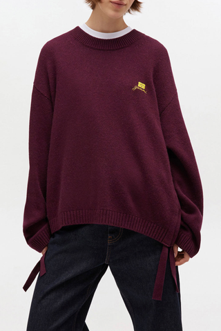 front profile model wearing Future Wool Mix Oversized O-Nk Sweater burgundy Round neck Ribbed edges GANNI logo Side tie details