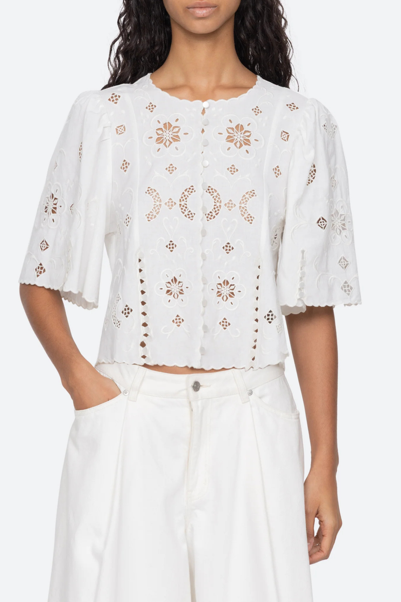 front profile model wearing Gardener Embroidered Short Sleeve Top white Eyelet detailing throughout
Scalloped edges
Flowing short sleeves
Cropped silhouette
Mother of pearl buttons
 cotton linen blenc