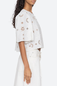 side profile model wearing Gardener Embroidered Short Sleeve Top white Eyelet detailing throughout
Scalloped edges
Flowing short sleeves
Cropped silhouette
Mother of pearl buttons
 cotton linen blenc
