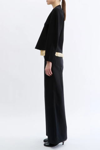 side profile model wearing Henry Knit Cardigan black Compact knitted
Structured viscose yarn
Elegant rounded shoulder
Flared peplum hem front button closure