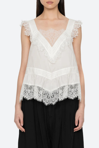 front profile model wearing  Hilda Solid Sleeveless Top White Soft v-neckline
Framed with floral lace trim
Fine pleated detailing
cotton nylon blend
Invisible side zipper