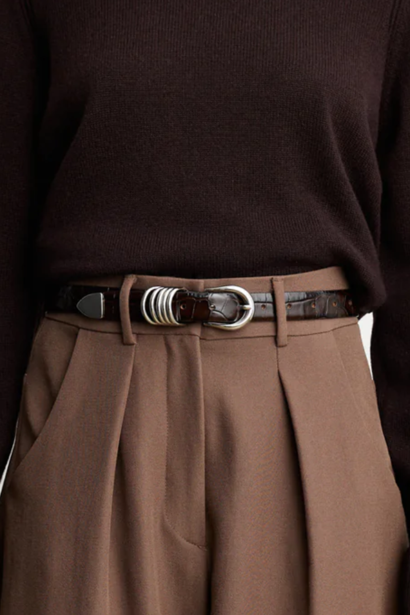 model wearing Hollyhock Belt Croc Silver Dark Chocolate 5 rings adornments
10 holes and an extended strap length to accommodate a broader range of sizes
Meticulously crafted from embossed Italian leather and silver hardware
Handcrafted in Italy
Silver Hardware
Genuine suede lining
1" Width