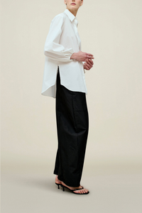 side profile model wearing Ilia Balloon Sleeve Blouse white with side slit