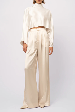 front profile model wearing  Ingrid Mock Neck Crop Top Champagne High neck
Clean hem design
Crop length
Flare sleeve
73% Acetate 27% Polyester
