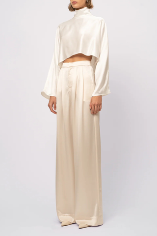 side profile model wearing  Ingrid Mock Neck Crop Top Champagne High neck
Clean hem design
Crop length
Flare sleeve
73% Acetate 27% Polyester