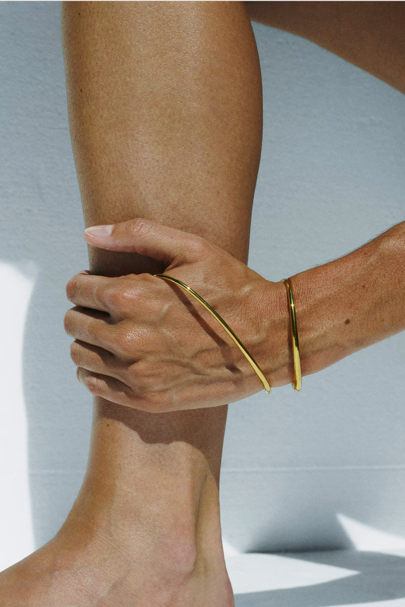 model wearing  Ivy Left Bracelet Vermeil Jewelry that climbs and snakes, landing and curving around the body in unconventional ways
Fluid and supple
Yellow vermeil
18 karats