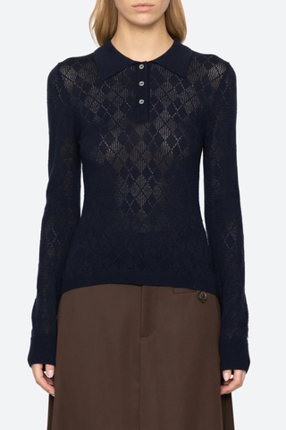 front profile model wearing  Jane Polo Sweater Navy Argyle polo sweater
Intricate argyle knit
Long sleeves
Custom patch at the sleeve
100% merino wool
Partial button front

Slimmer fit