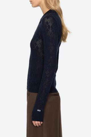 side profile model wearing  Jane Polo Sweater Navy Argyle polo sweater
Intricate argyle knit
Long sleeves
Custom patch at the sleeve
100% merino wool
Partial button front

Slimmer fit