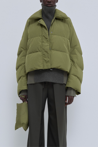 front profile model wearing  Jani Puffer Jacket Olive Cropped signature down jacket
Soft water-repellent nylon
Oversized silhouette
Voluminous sleeves
Statement collar
Concealed snap buttons
Zip closure
Adjustable drawcord hem
100% Nylon