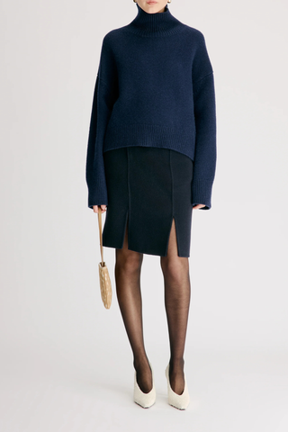 front profile model wearing Jonah Loose Fit T-Neck Sweater Navy Dense cashmere
Slightly cropped
Boxy fit
Drop shoulders
Thick stand collar
Ribbed details
100% Cashmere