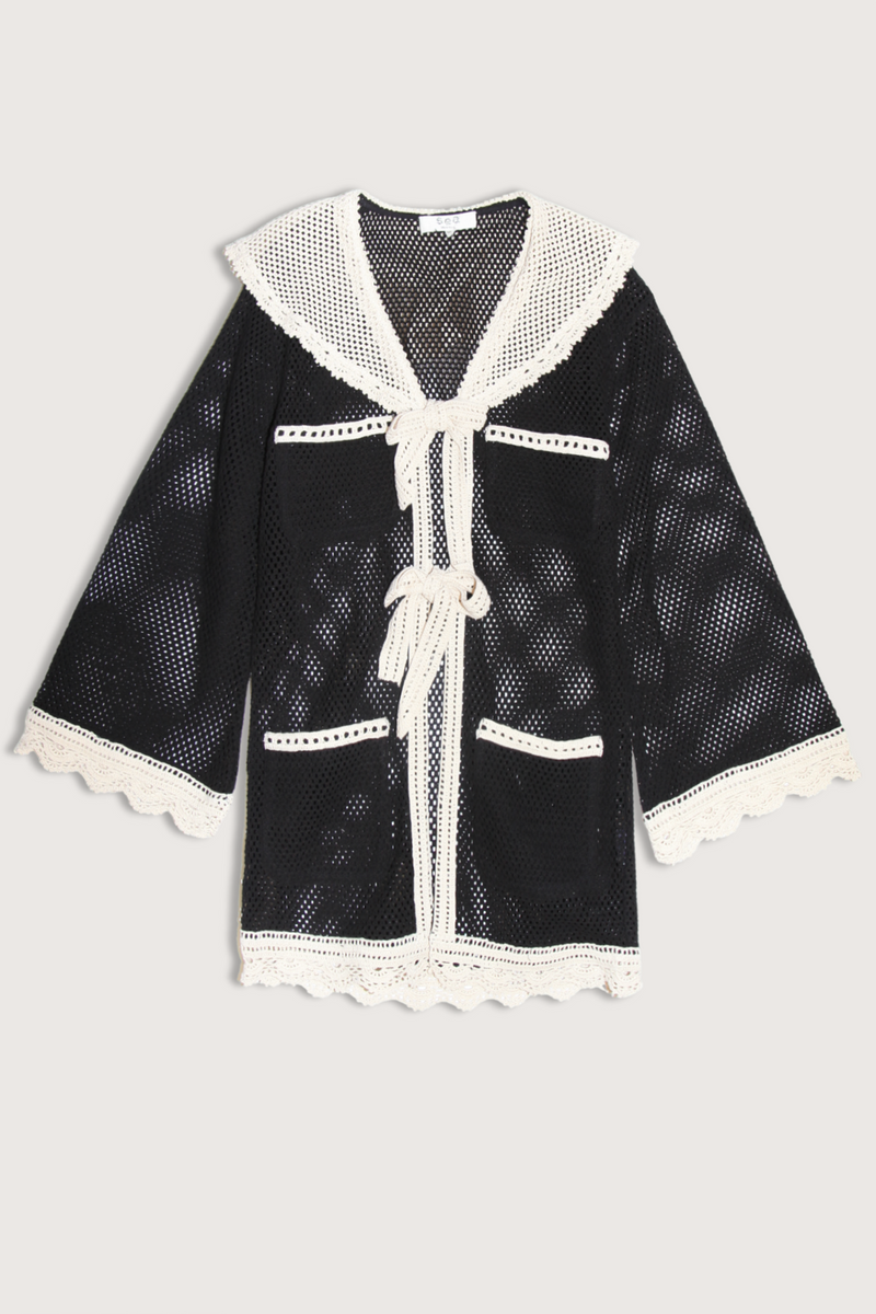 flat lay Kendall Crochet Cover Up black white Crochet
Two front ties
Scallop lace detailing
Contrast white crocket pocket design
Large sailor collar