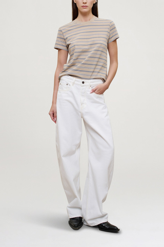 front profile model wearing Kenzie Stripe Short Sleeve T-Shirt Almond Stripe
Handmade custom stripe
Relaxed boxy fit
Subtle cropped length
Roomy sleeves
Slight taper at waist
Shifted side seams give tailored look
Solid knit binding at neckline
Features contrast Kallmeyer embroidery at hem
100% Cotton
