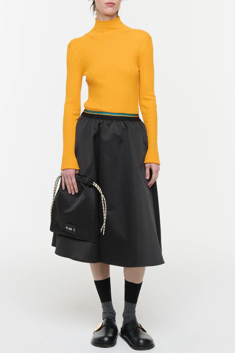front profile model wearing Knee Length Skirt With Elastic Waist black Midi skirt
Structured black duchesse
A-line silhouette
Striped elasticated waistband
100% Polyester |&nbsp; lining 100% cotton