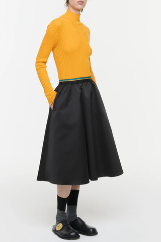 side profile model wearing Knee Length Skirt With Elastic Waist black Midi skirt
Structured black duchesse
A-line silhouette
Striped elasticated waistband
100% Polyester |&nbsp; lining 100% cotton