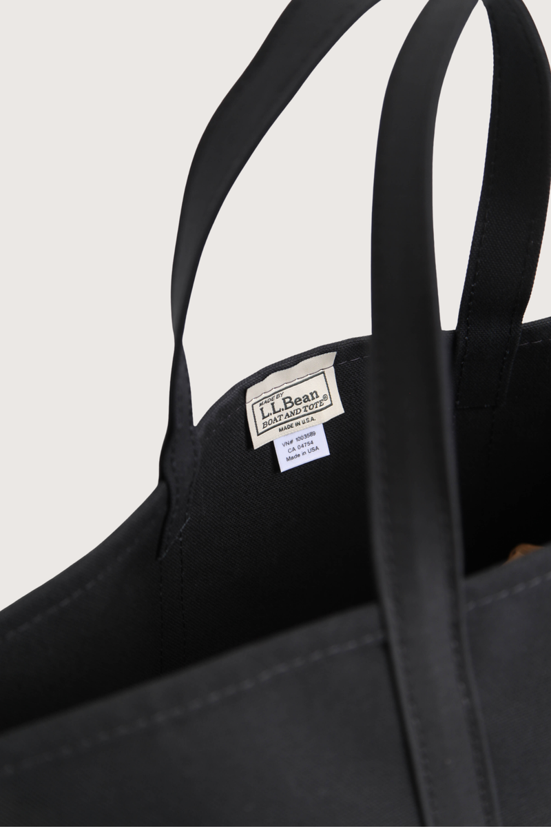 close up logo inside detail  L.L.Bean X Lutz Morris M Tote Bag black A collaboration with L.L.Bean &amp; Lutz Morris
Classic Boat and Tote in monochrome black
Outer pocket embossed and hand-painted calf leather to resemble lizzard with 24k gold-plated stainless steel hardware
Heavyweight canvas
Reinforced handles
Double-stitched seams

crafted in Maine, one tote at a time
Medium
Capacity: Approx. 1,008 cu. in., 17 L
Dimensions: 12"H x 13"W x 6"D
Handles: Regular 6"