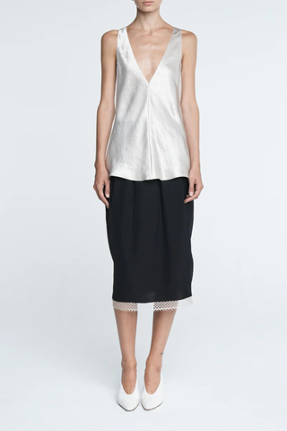 front profile model wearing  Lace Tulip Skirt Black
Elastic waistband
Hidden side pockets
Bouncy, lightweight Japanese Naia twill
Midi length
Slit at back
White lace hem
